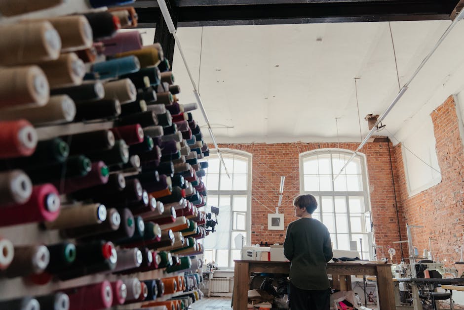 A vibrant display of sewing threads in a contemporary workshop with a brick wall interior.