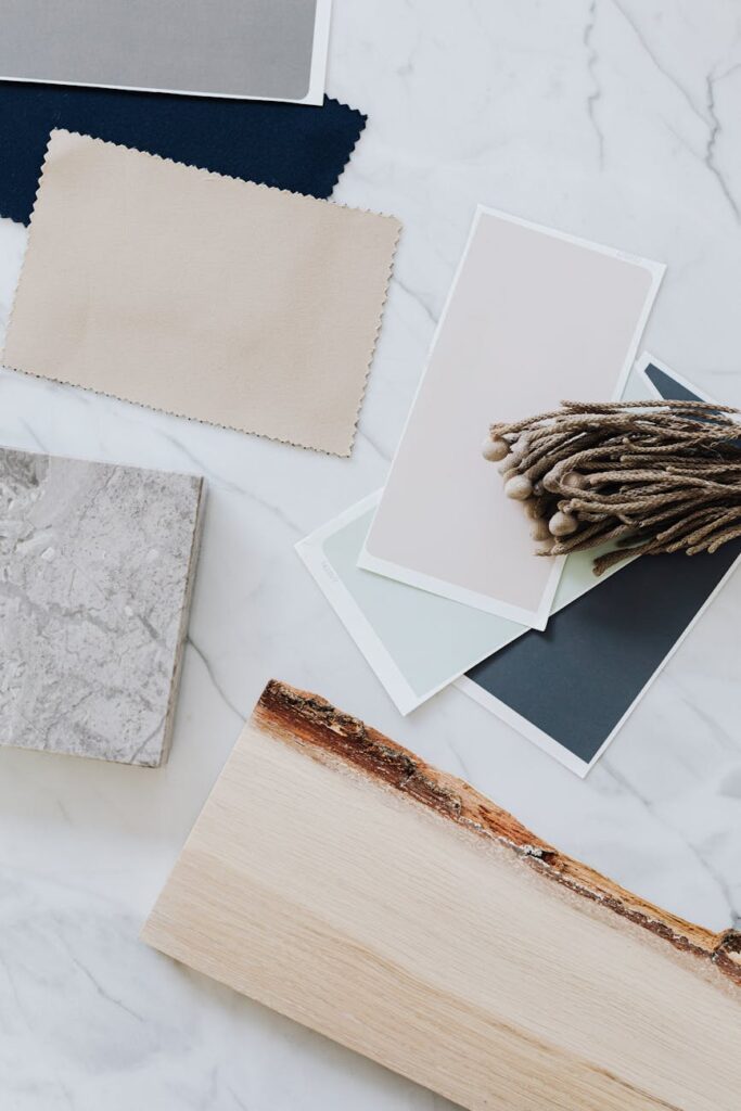 Flat lay of material samples for interior design including wood, marble, and textiles.